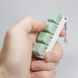 A hand holding the Strudel 3D 4 Key Fidget Stick - Mint Green.